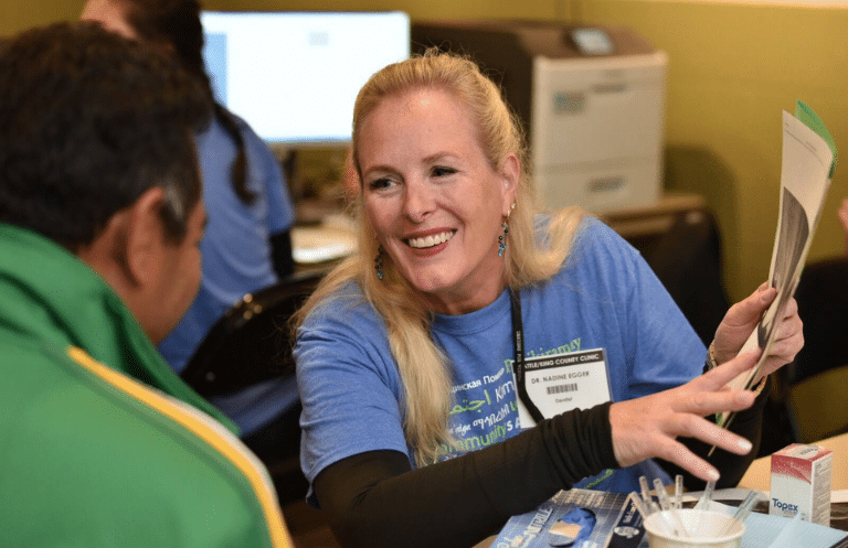 Dr. Nadine Egger smiling while reviewing a patient's dental chart.