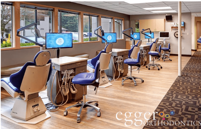 Modern orthodontic treatment bay with blue chairs at Egger Orthodontics.